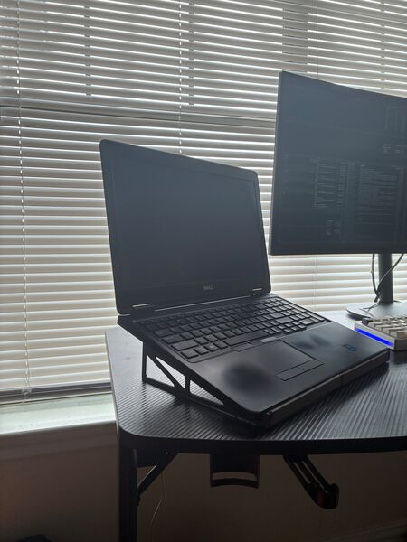 A laptop resting on the stand in the low orientation, raised at the rear.
