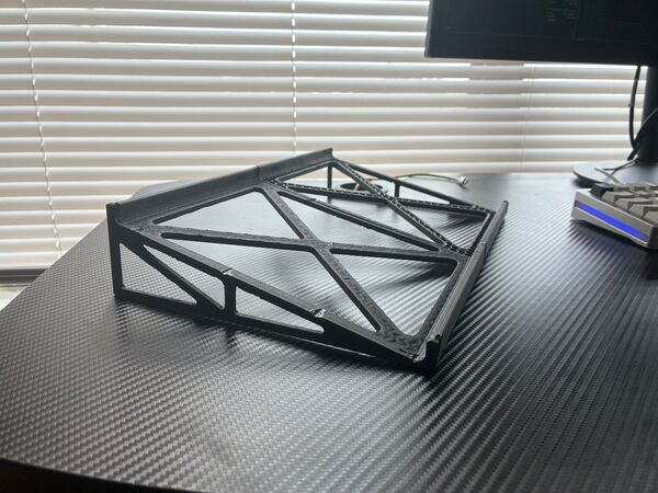 Three-quarter view of the empty stand in laptop mode, showing the side trusses and X-braced top.