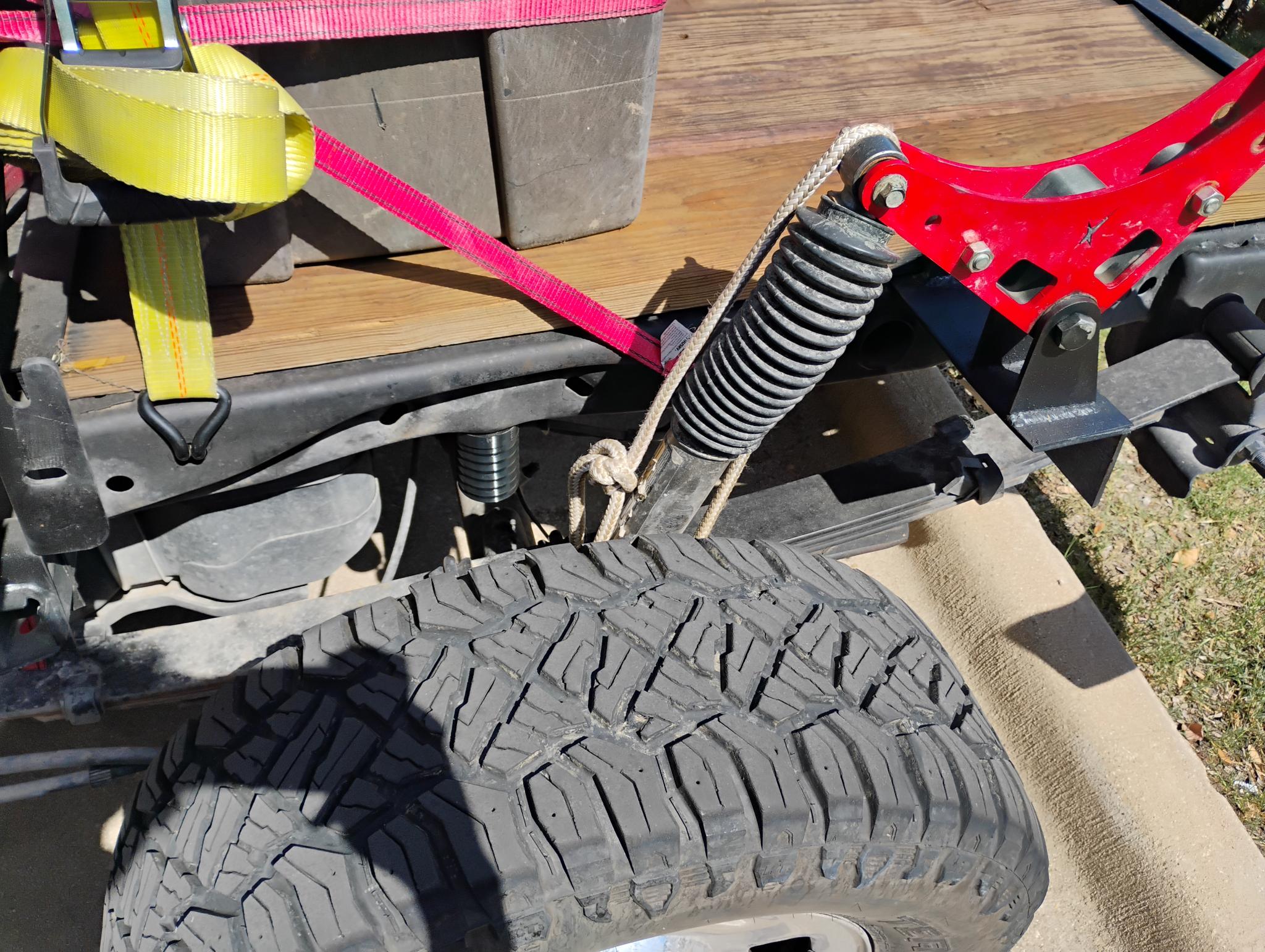POLYSTOP mounted on the rear frame of a first-generation Ford Raptor, the ribbed body sitting between the frame rail and the axle